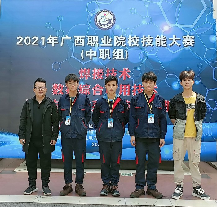 覃業(yè)彬老師（左一）、楊志文老師（右一）指導(dǎo)的黃建達（左二）、廖文富（中間）、黎學(xué)軍（右二）三位學(xué)生獲得和參加數(shù)控綜合應(yīng)用技術(shù)項目二等獎.jpg